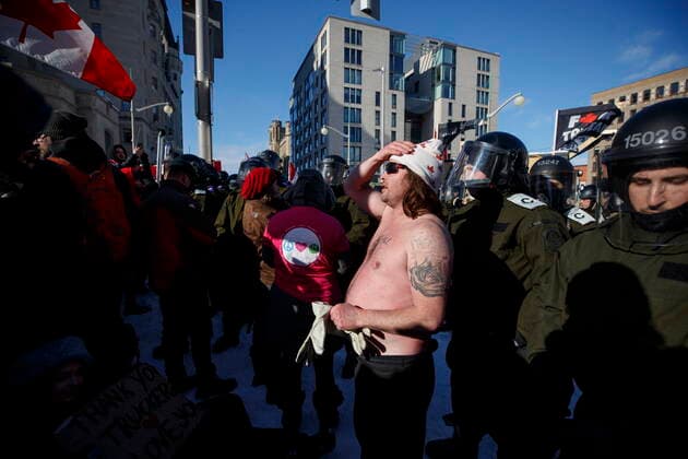 February 18, 2022, OTTAWA, ON, CANADA: Police officers push back protestors during a protest against COVID-19 measures that has grown into a broader anti-government protest continues to occupy downtown Ottawa on Friday, Feb. 18, 2022. OTTAWA CANADA  - ZUMAc35_ 20220218_zaf_c35_238 Copyright: xColexBurstonx