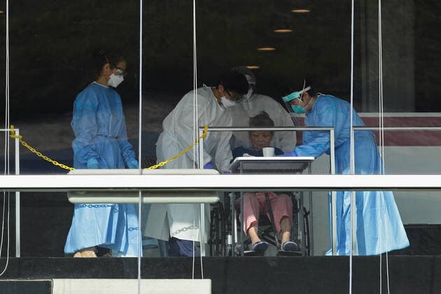 Daily Life In Singapore Amid The COVID-19 Pandemic Healthcare workers dressed in personal protective equipment (PPE) attend to a coronavirus disease (COVID-19) patient at the Formula One Pit building, which was converted into a treatment facilities for seniors who are infected with COVID-19 on February 19, 2022 in Singapore. Singapore Singapore  Copyright: xSuhaimixAbdullahx originalFilename: abdullah-notitle220219_npLHf.jpg