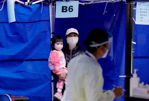 February 19, 2022, HONG KONG, CHINA: A mother and daughter awaiting to be moved into hospital building for medical treatment outside Caritas Medical Centre under the cold rain.In Hong Kong, approximately 30 percent of Covid infected patients are consist of senior citizens and children.Feb-19,2022Hong Kong.ZUMA HONG KONG CHINA - ZUMAl137 20220219_zap_l137_012 Copyright: xLiauxChung-renx