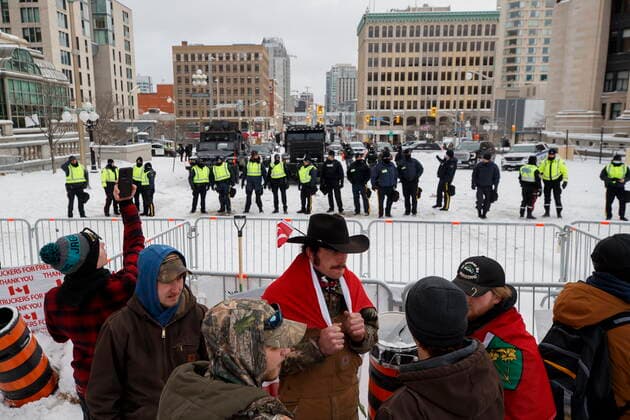 February 19, 2022, OTTAWA, ON, CANADA: Protestors gather near a police line in downtown Ottawa on Saturday, Feb. 19, 2022. Police arrested scores of demonstrators and towed away vehicles Friday in Canada s besieged capital, and a stream of trucks started leaving under the pressure, raising authorities hopes for an end to the three-week protest against the country s COVID-19 restrictions. OTTAWA CANADA  - ZUMAc35_ 20220219_zaf_c35_040 Copyright: xColexBurstonx