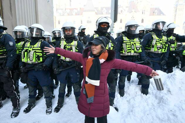 February 19, 2022, Ottawa, ON, Canada: A woman stands in front of police as move they in to clear downtown Ottawa near Parliament hill of protesters after weeks of demonstrations on Saturday, Feb. 19, 2022. Police arrested scores of demonstrators and towed away vehicles Friday in Canada s besieged capital, and a stream of trucks started leaving under the pressure, raising authorities hopes for an end to the three-week protest against the country s COVID-19 restrictions. Ottawa Canada  - ZUMAc35_ 20220219_zaf_c35_071 Copyright: xJustinxTangx