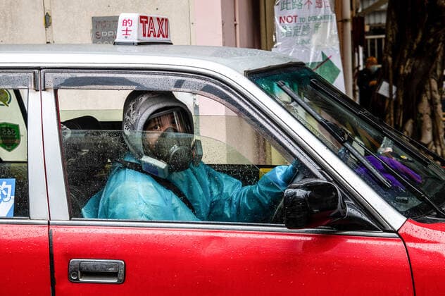 News Bilder des Tages February 19, 2022, Hong Kong, China: A taxi driver in full PPE pulls out of a COVID-19 clinic in Shau Kei Wan..A fleet of around 300 designated taxis were launched recently to ferry passengers to and from designated COVID-19 clinics in Hong Kong. The drivers are provided with PPE and a 3000 HKD per day stipend from the government, while passengers ride for free (pending approval of their booking). Drivers are required to clean their vehicles thoroughly between rides, take regular COVID-19 tests, and passengers may only sit in the back. Hong Kong China - ZUMAs197 20220219_zaa_s197_017 Copyright: xBenxMaransx