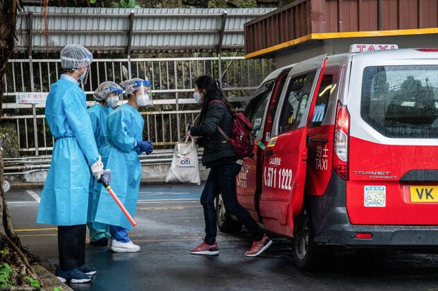February 19, 2022, Hong Kong, China: A passenger is greeted by staff at the Shau Kei Wan Designated COVID-19 Clinic..A fleet of around 300 designated taxis were launched recently to ferry passengers to and from designated COVID-19 clinics in Hong Kong. The drivers are provided with PPE and a 3000 HKD per day stipend from the government, while passengers ride for free (pending approval of their booking). Drivers are required to clean their vehicles thoroughly between rides, take regular COVID-19 tests, and passengers may only sit in the back. Hong Kong China - ZUMAs197 20220219_zaa_s197_036 Copyright: xBenxMaransx