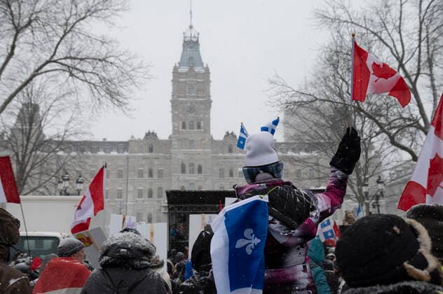 February 19, 2022, QUEBEC, PQ, Canada: A person waves a Canadian flag as hundreds of people demonstrate against COVID-19 measures in front of the legislature in Quebec City, Saturday, Feb. 19, 2022. QUEBEC Canada  - ZUMAc35_ 20220219_zaf_c35_098 Copyright: xJacquesxBoissinotx