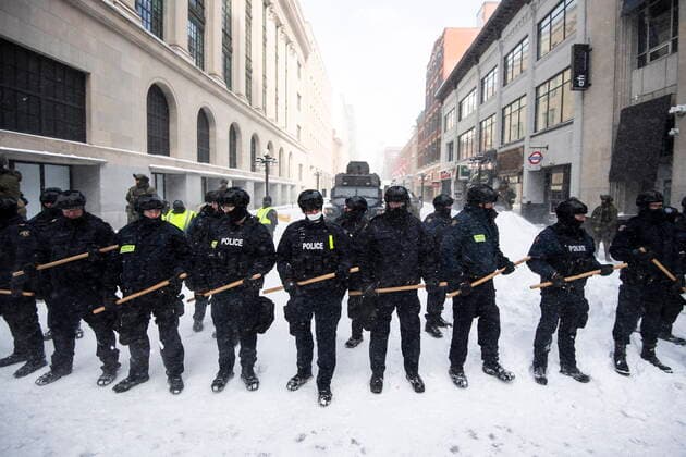 February 19, 2022, Ottawa, ON, Canada: Police clutch batons as they form a line to block Sparks Street, restricting access to the streets near Parliament Hill, they take action to put an end to a protest, which started in opposition to mandatory COVID-19 vaccine mandates and grew into a broader anti-government demonstration and occupation, on its 23rd day, in Ottawa, Saturday, Feb. 19, 2022. Ottawa Canada - ZUMAc35_ 20220219_zaf_c35_156 Copyright: xJustinxTangx