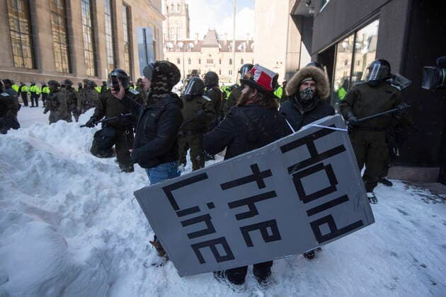 News Bilder des Tages February 19, 2022, Ottawa, ON, Canada: A protester wears a giant placard with a call to Hold the Line, as police work to clear the streets in front of Parliament Hill to put an end to a protest, which started in opposition to mandatory COVID-19 vaccine mandates and grew into a broader anti-government demonstration and occupation, on its 23rd day, in Ottawa, Saturday, Feb. 19, 2022. Ottawa Canada - ZUMAc35_ 20220219_zaf_c35_174 Copyright: xJustinxTangx