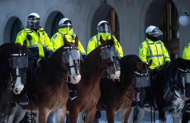 February 19, 2022, Ottawa, ON, Canada: Toronto Police mounted unit stand on Wellington Street as police work to clear the streets in front of Parliament Hill to end to a protest, which started in opposition to mandatory COVID-19 vaccine mandates and grew into a broader anti-government demonstration and occupation, on its 23rd day, in Ottawa, Saturday, Feb. 19, 2022. Ottawa Canada - ZUMAc35_ 20220219_zaf_c35_176 Copyright: xJustinxTangx