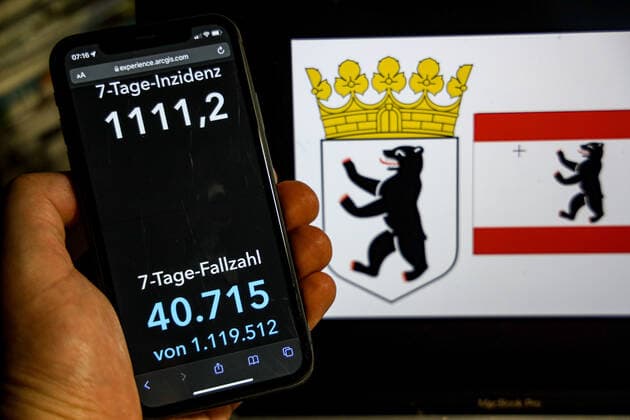 Coronavirus in Deutschland - Covid-19-Dashboard des Robert Koch-Institut DEU, Deutschland, Berlin 20.02.2022: Die 7-Tage-Inzidenz für das Bundesland (Fälle letzte 7 Tage 100.000 EW) wird auf einem iPhone angezeigt, im Hintergrund das Landeswappen