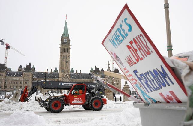 News Bilder des Tages February 20, 2022, Ottawa, ON, Canada: Machinery moves a concrete barricade past the Parliament buildings and a container of garbage from the Trucker protest which has occupied the streets of Ottawa, Sunday, February 20, 2022. Ottawa Canada  - ZUMAc35_ 20220220_zaf_c35_038 Copyright: xAdrianxWyldx