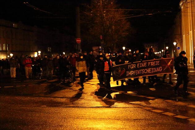 Demonstranten laufen mit Banner Für eine freie Impfentscheidung über die Friedrich-Ebert-Straße während einer Demonstration gegen die Impfpflicht in der Coronavirus-Pandemie, Potsdam, 21. Februar 2022. Demo gegen Impfpflicht