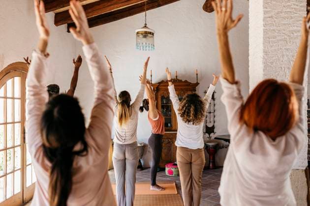 Friends and yoga instructor stretching hands in yoga studio model released property released, JRFF05301