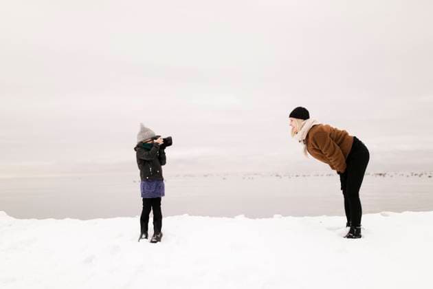 Daughter photographing mother through camera in winter model released, ANF00080