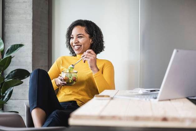 Happy businesswoman with salad bowl at work place model released property released, UUF25472