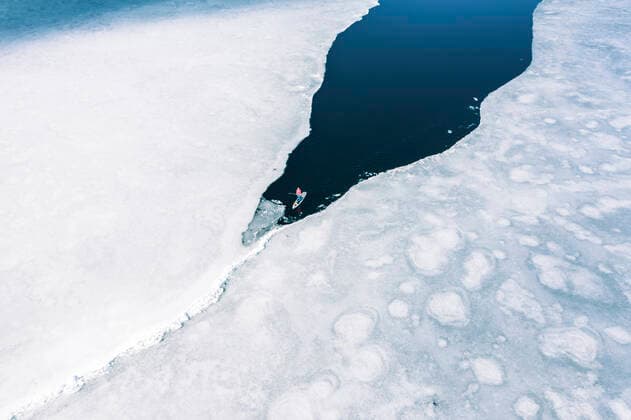IMAGO Creative, Winter, Winterspaß, Eishockey Germany, Bavaria, Aerial view of lone man paddleboarding between ice floes in Eibsee lake model released, Grainau Bayern Deutschland Eibsee WFF00683