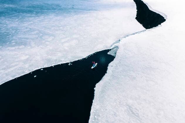 IMAGO Creative, Winter, Winterspaß, Eishockey Germany, Bavaria, Aerial view of lone man paddleboarding between ice floes in Eibsee lake model released, Grainau Bayern Deutschland Eibsee WFF00685