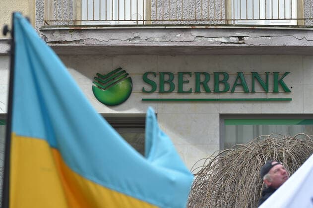 Ukrainian flag outside the branch of Russian bank Sberbank in Karlovy Vary, Czech Republic, on February 25, 2022. In connection with the Russian army s attack on Ukraine, US President Joe Biden announced economic sanctions against Russian banks Sberbank and VTB. (CTKxPhoto SlavomirxKubes) CTKPhotoP2022022505866  KBS_08
