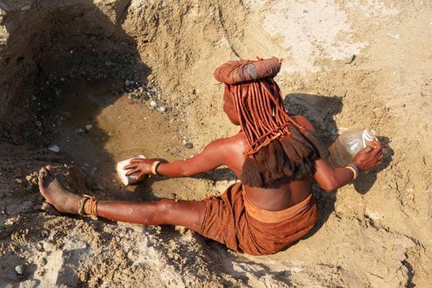 IMAGO Cultures of the world, Himba Volk in Namibia Himba-Frau beim Wasserholen an einem Wasserloch, am Ufer des trockenen Flussbettes des Hoarusib-Flusses, Kaokoland, Kunene-Region, Namibia, Afrika *** Himba woman fetching water at a waterhole, on the bank of the dry riverbed of the Hoarusib River, Kaokoland, Kunene Region, Namibia, Africa Copyright: imageBROKER/ThomasxDressler ibxtdr08170557.jpg