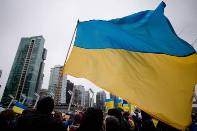 February 26, 2022, Vancouver, British Columbia, Canada: A Ukrainian flag flies through the crowd at a rally supporting Ukraine. Vancouver Canada  - ZUMA Pho 20220226_mda_w171_177 Copyright: xRyanxWalterxWagnerx