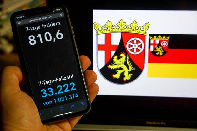 Coronavirus in Deutschland - Covid-19-Dashboard des Robert Koch-Institut DEU, Deutschland, Rheinland-Pfalz 27.02.2022: Die 7-Tage-Inzidenz für das Bundesland (Fälle letzte 7 Tage 100.000 EW) wird auf einem iPhone angezeigt, im Hintergrund das Landeswappen
