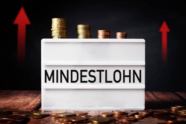 27 February 2022: minimum wage in Germany, light box with inscription minimum wage more money with euro coins FOTOMOTNAGE *** Mindestlohn in Deutschland, Licht Box mit der Aufschrift Mindest Lohn mehr Geld mit Euro Münzen FOTOMOTNAGE