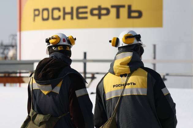 SAMARA REGION, RUSSIA - FEBRUARY 24, 2022: Employees are seen by an oil tank battery at the Novokuibyshevsk Refinery, a subsidiary of Rosneft Oil Company, in the city of Novokuibyshevsk 20 km southwest of Samara. The enterprise s primary distillation capacity is 8.8 million tons per year. The Novokuibyshevsk Refinery is one of the major manufacturers and suppliers of the superior grade of fuel for jet engines of the brand RT, the most in-demand type in Russia. Yegor Aleyev TASS  TS125BAB