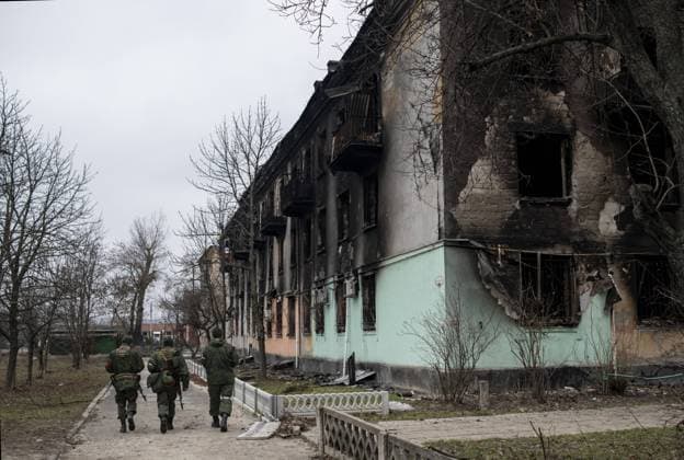 Ukraine-Krieg, Jahrestag der Invasion, Chronologie der Ereignisse, Archivbilder News Bilder des Tages DPR LPR Russia Ukraine Military Operation 8129551 01.03.2022 Servicemen pass by a residential building destroyed by the shelling, in Shchastia, Luhansk People s Republic. Valery Melnikov Luhansk People s Republic  Copyright: xValeryxMelnikovx