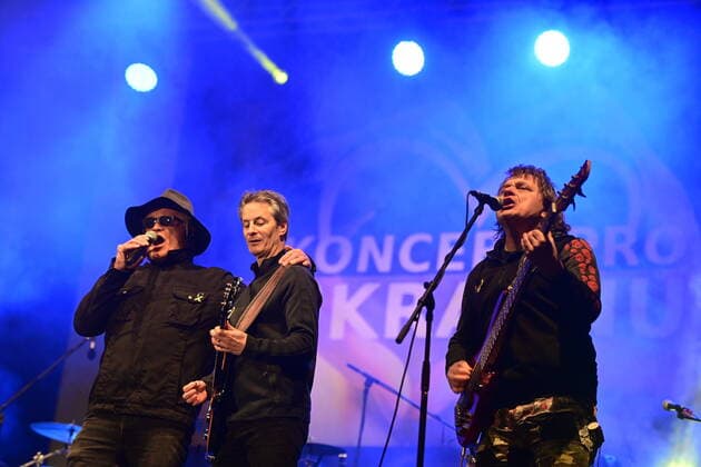 (from left) Singer Michael Kocab, who led a parliament commission which negotiated the repatriation of Soviet soldiers from Czechoslovakia in 1990, the Czech National Symphonic Orchestra (CNSO) chief conductor Steven Mercurio and Prazsky vyber Band guitarist Vilem Cok perform during a benefit concert for Ukraine, which took place on Wenceslas Square in Prague, Czech Republic, on Tuesday, March 1st, 2022. (CTKxPhoto RomanxVondrous) CTKPhotoP2022030110777 