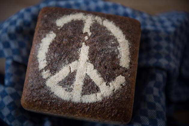 Ein Brot mit einem Peace Symbol, einem Friedenszeichen der Kampagne zur nuklearen Abruestung (Campaign for Nuclear Disarmament CND), aus Mehl liegt fuer eine Fotoillustration auf einem Tisch. Foto: bildgehege Friedensbrot *** A bread with a peace symbol, a peace sign of the Campaign for Nuclear Disarmament CND , made of flour lies on a table for a photo illustration photo bildgehege peace bread