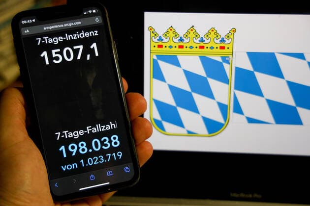 Coronavirus in Deutschland - Covid-19-Dashboard des Robert Koch-Institut DEU, Deutschland, Bayern 06.03.2022: Die 7-Tage-Inzidenz für das Bundesland (Fälle letzte 7 Tage 100.000 EW) wird auf einem iPhone angezeigt, im Hintergrund das Landeswappen