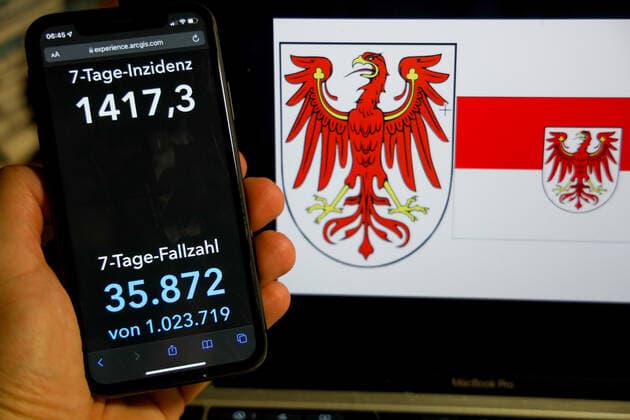 Coronavirus in Deutschland - Covid-19-Dashboard des Robert Koch-Institut DEU, Deutschland, Brandenburg 06.03.2022: Die 7-Tage-Inzidenz für das Bundesland (Fälle letzte 7 Tage 100.000 EW) wird auf einem iPhone angezeigt, im Hintergrund das Landeswappen