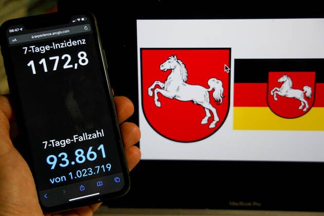 Coronavirus in Deutschland - Covid-19-Dashboard des Robert Koch-Institut DEU, Deutschland, Niedersachsen 06.03.2022: Die 7-Tage-Inzidenz für das Bundesland (Fälle letzte 7 Tage 100.000 EW) wird auf einem iPhone angezeigt, im Hintergrund das Landeswappen