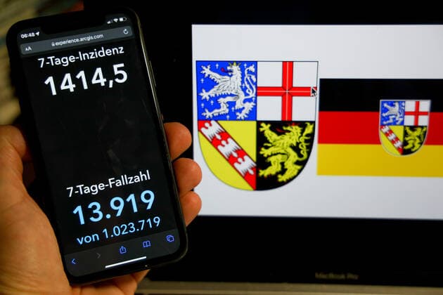 Coronavirus in Deutschland - Covid-19-Dashboard des Robert Koch-Institut DEU, Deutschland, Saarland 06.03.2022: Die 7-Tage-Inzidenz für das Bundesland (Fälle letzte 7 Tage 100.000 EW) wird auf einem iPhone angezeigt, im Hintergrund das Landeswappen