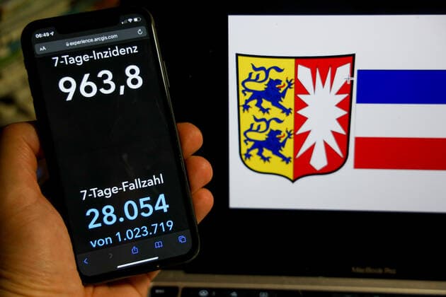 Coronavirus in Deutschland - Covid-19-Dashboard des Robert Koch-Institut DEU, Deutschland, Schleswig-Holstein 06.03.2022: Die 7-Tage-Inzidenz für das Bundesland (Fälle letzte 7 Tage 100.000 EW) wird auf einem iPhone angezeigt, im Hintergrund das Landeswappen
