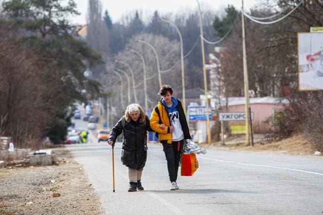ZAKARPATTIA REGION, UKRAINE - MARCH 8, 2022 - A boy supports an elderly woman leaning on a walking cane as they are forced to flee due to the Russian invasion at the Uzhhorod-Vysne Nemecke checkpoint on the Ukraine-Slovakia border, Zakarpattia Region, western Ukraine. Refugees at Ukraine-Slovakia border  Copyright: xSerhiixHudakx