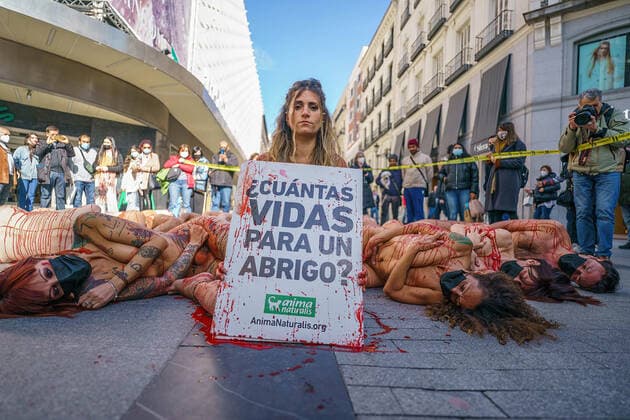 March 13, 2022, Madrid, Spain: (EDITOR s NOTE: Image contains profanity).Naked demonstrators covered in fake blood lie on Preciados street as one holds a placard reading How many lives for a coat ? during a protest against the fur industry No Fur 2022 , in Madrid. The rally has been called as every year by the animal rights organization AnimaNaturalis to eradicate the use of animal fur in fashion and accessories. AnimalNaturalis was born to give a voice for animals that are used by humans for commercial purposes. Madrid Spain - ZUMAs197 20220313_zaa_s197_190 Copyright: xAtilanoxGarciax