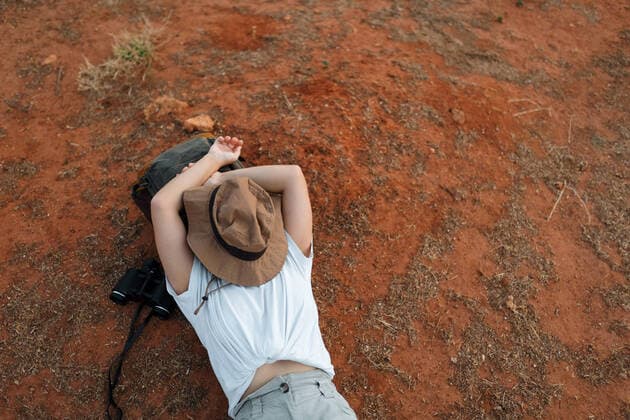 Creative Highlights Symbolbilder From above unrecognizable female traveler with hat on face lying on dry ground during trip in desert terrain AlbertoOrtega_YoungWomanExplorerDesert_86.jpg Copyright: xAlbertoxOrtegax Model Released