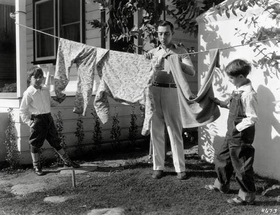 Buster Keaton with his two sons, Joseph and Robert, hanging laundry outside his Bungalow in Culver City, circa 1929. File Reference 34145-719THA  Copyright: xCinemaxLegacyxCollection ThexHollywoodxArchivex 34145-719THA