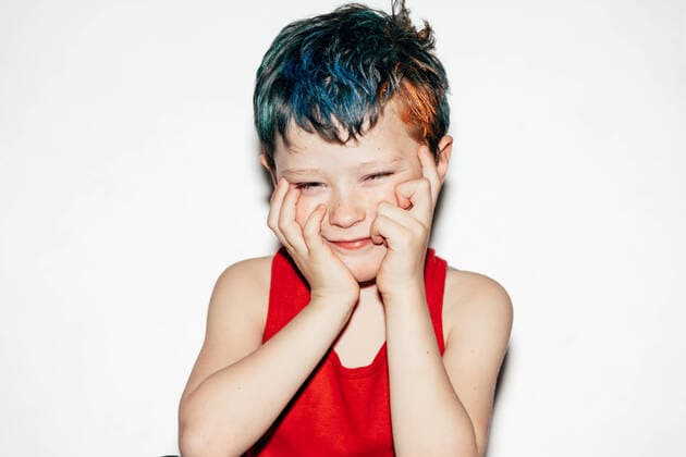 Creative Highlights Symbolbilder Rebellious boy with dyed hair looking away and touching face with hands while standing on white background in room HodeiUnzueta_NaughtyBoy_19.jpg Copyright: xHodeixUnzuetax Model Released