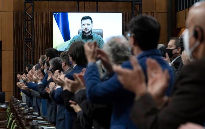 Bilder des Jahres 2022, News 03 März News Themen der Woche KW11 News Bilder des Tages March 15, 2022, Ottawa, ON, Canada: Canadian Members of Parliament and invited guests applaud as Ukrainian President Volodymyr Zelenskyy is shown on a giant video screen before addressing the Canadian parliament, Tuesday, March 15, 2022 in Ottawa. Ottawa Canada  - ZUMAc35_ 20220315_zaf_c35_001 Copyright: xAdrianxWyldx
