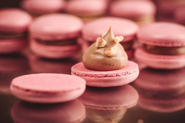 Macarons closeup on white wooden background. Sweet and colourful pink french macaroons. Cooking at home. Copyright: xDmytroxNikolaienkox