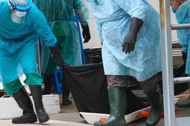 March 18, 2022, Hong Kong, China: Workers with PPE transport bodies to a truck at a public mortuary. Hong Kong health authorities have set up refrigerated shipping containers outside a public mortuary to store dead bodies as mortuaries and hospitals are running out of space. Hong Kong China - ZUMAt141 20220318_zap_t141_006 Copyright: xKeithxTsujix