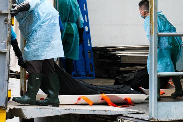 March 18, 2022, Hong Kong, China: Workers with PPE transport bodies to a truck at a public mortuary. Hong Kong health authorities have set up refrigerated shipping containers outside a public mortuary to store dead bodies as mortuaries and hospitals are running out of space. Hong Kong China - ZUMAt141 20220318_zap_t141_007 Copyright: xKeithxTsujix