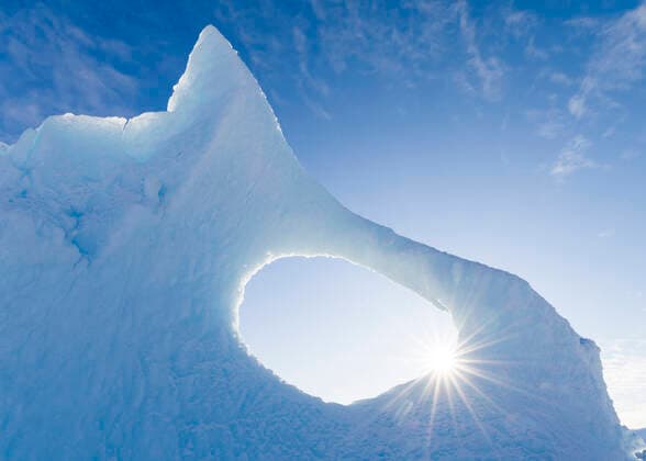Iceberg frozen into the sea ice of the Uummannaq fjord system during winter in the the north west of Greenland, far beyond the polar circle. North America, Greenland, danish territory MartinZwick REDA&CO 1028_38_MZW14280