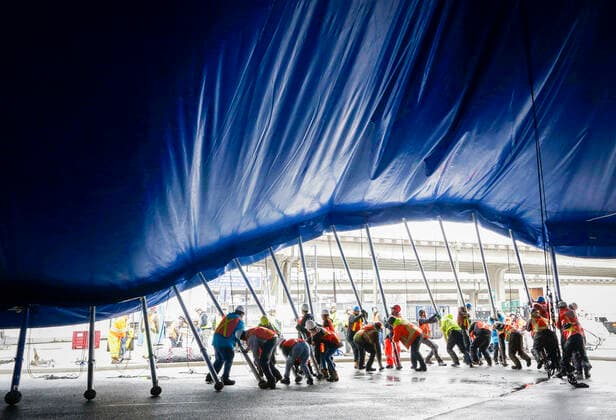 (220319) -- VANCOUVER, March 19, 2022 -- Workers push the supporting poles to raise the big top to its final position for the Cirque du Soleil s upcoming show Alegria at Concord Pacific Place in Vancouver, British Columbia, Canada, on March 18, 2022. More than 60 workers pushed over 100 supporting poles to raise the canvas into its final position in order to set up the the iconic Big Top - where the main stage of Cirque du Soleil will take place. (Photo by Xinhua) CANADA-VANCOUVER-CIRQUE DU SOLEIL-BIG TOP-RAISING LiangxSen 