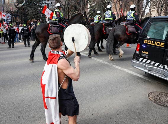 March 19, 2022, Calgary, AB, CANADA: A man bangs a drum as he taunts police as hundreds of demonstrators gather at city hall in Calgary, Alta., Saturday, March 19, 2022. Calgary CANADA  - ZUMAc35_ 20220319_zaf_c35_051 Copyright: xJeffxMcintoshx