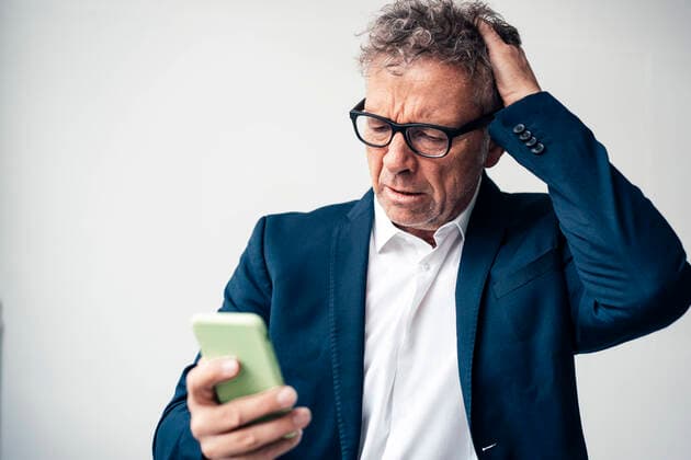 Frustrated businessman using smart phone against white background model released property released, JOSEF07300