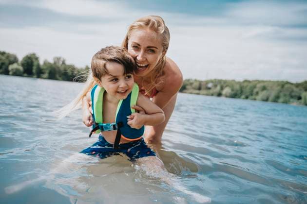 Happy mother playing with son in lake model released, MFF08695