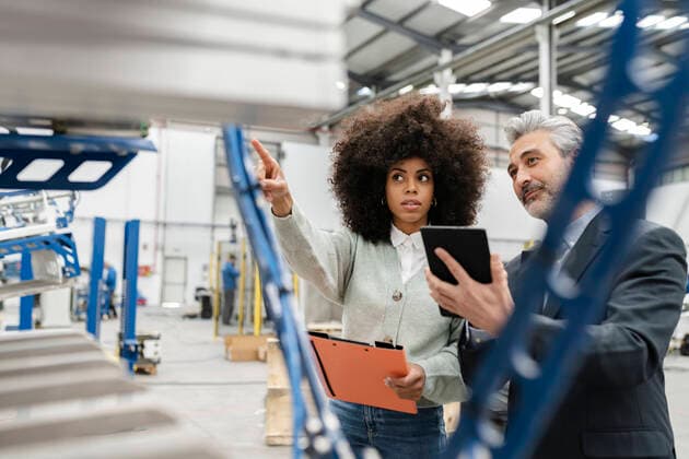 IMAGO Creative: Business, Inflation und Lieferketten Technician showing machine to businessman with tablet PC in factory model released property released, JCCMF05539