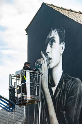 Bilder des Jahres 2022, News 03 März News Themen der Woche KW12 News Bilder des Tages Finishing touches are added to a mural of music icon Ian Curtis in Macclesfield, where the music icon grew up, in the town centre on 25 March 2022. The painting has been created by street artist Akse in memory of the Joy Division frontman, who died in 1980. The artwork is based on a photograph by Kevin Cummins and was commissioned by Cheshire East Council who said it has pride of place in the town . Curtis was brought up in the town and is buried in Macclesfield Cemetery, was the lead singer of Joy Division until his death at the age of 23 in May 1980. The three surviving members of the band resolved to carry on and renamed themselves as New Order. Macclesfield Cheshire England Town Centre  Copyright: xMattxWilkinsonx