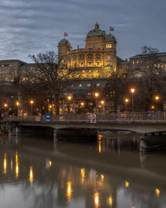 Switzerland, Canton of Bern, Bern, Dalmazi Bridge at dusk with Federal Palace in background, KEBF02259